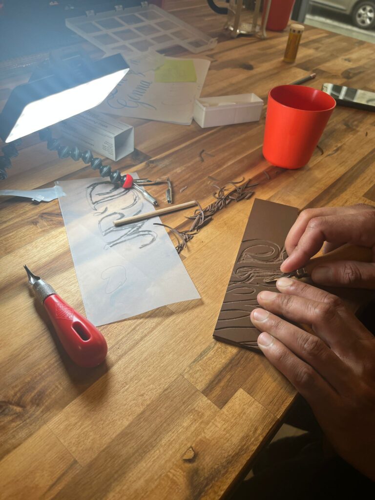 Kevin réalisant la gravure de sa forme extraite d’une planche calligraphique.