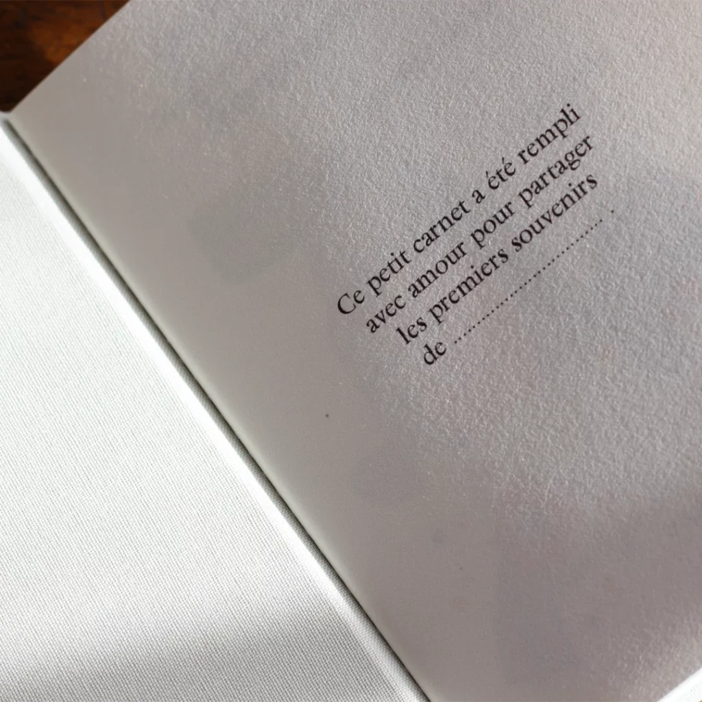 Carnet de naissance personnalisable ouvert, toile blanche, page de garde, vue de haut zoom