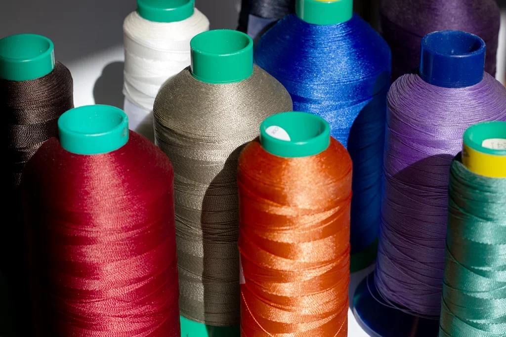 Cônes de fil à couture Amann d'exception disponibles à l'atelier pour la reliure Singer.