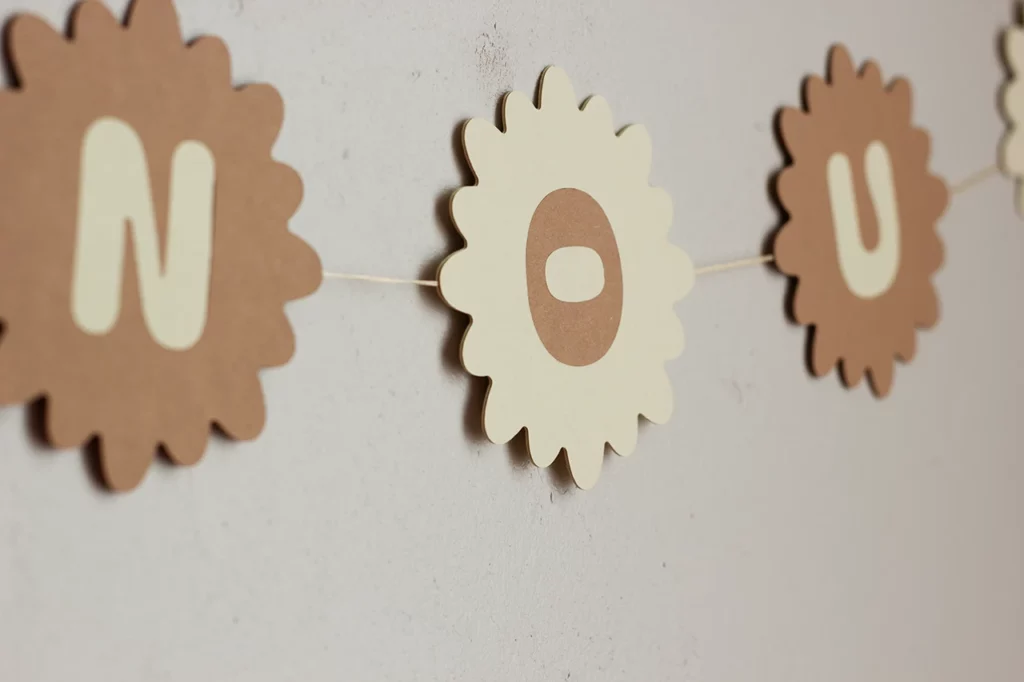 Zoom sur la guirlande prénom en marqueterie de papier personnalisable, avec le prénom Anouk, couleur vanille et cocos. Zoom sur la guirlande prénom en marqueterie de papier personnalisable, avec le prénom Anouk, couleur vanille et cocos.