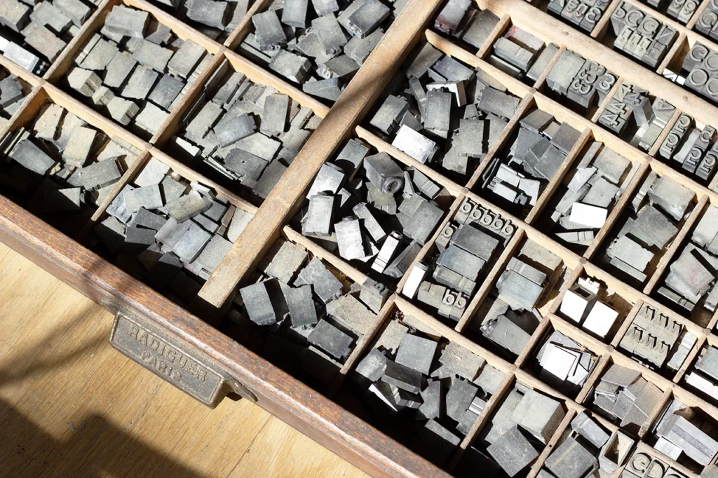 Casse typographique Radiguer (Paris), compartimentée en cassetins, contenant les caractères de la famille Antique 12 grasse corps 36.