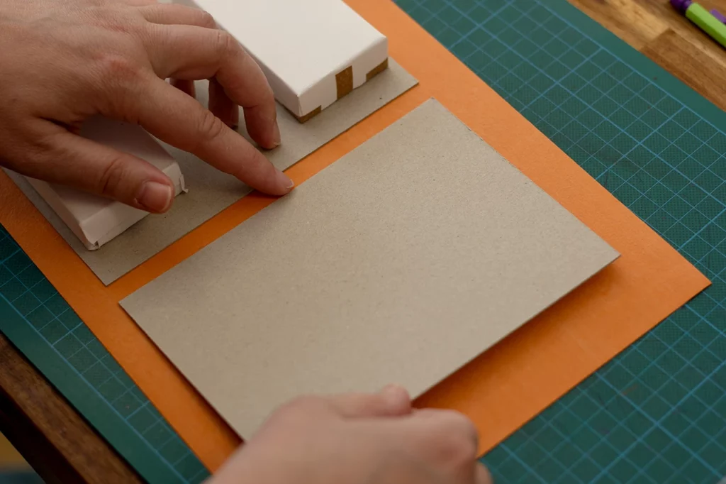 Contrecollage du carton gris sur le cuir de pomme, avec mise sous poids.